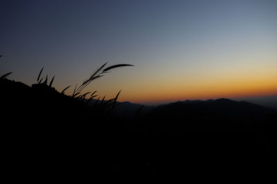 Scenic view of silhouette land against clear sky during sunset