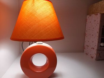Close-up of illuminated lamp on table at home