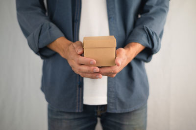 Midsection of man holding camera in box