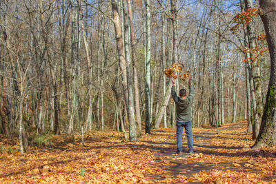 Man standing by trees in forest during autumn