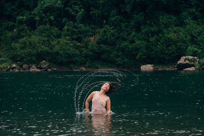Woman tossing hair in lake