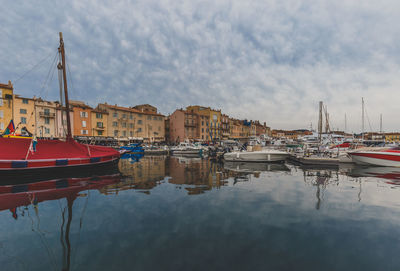 Boats moored in water against sky