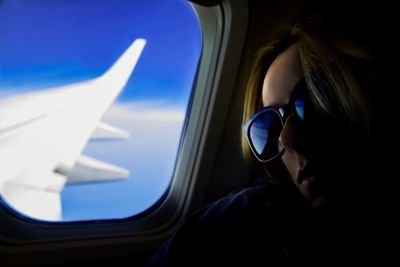 Close-up of woman sitting by airplane window