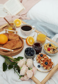 Romantic breakfast with coffee, waffles, orange juice and rose flowers.