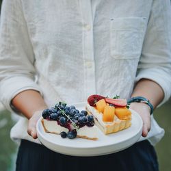 Midsection of woman holding fruit