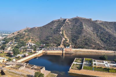 Scenic view of buildings and mountains against clear blue sky