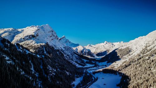 Scenic view of snowcapped mountains against clear blue sky