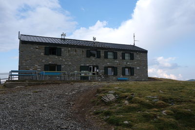 Low angle view of old house on field against sky