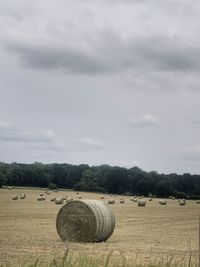 Hay bales on field against sky