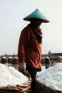 Rear view of man standing on snow against sky