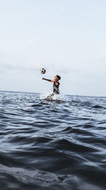 Man surfing in sea against sky