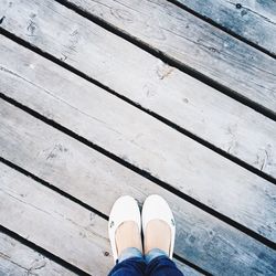 Low section of woman standing on wooden plank