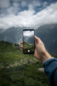 Midsection of person photographing camera on mobile phone
