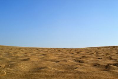 Scenic view of desert against clear blue sky