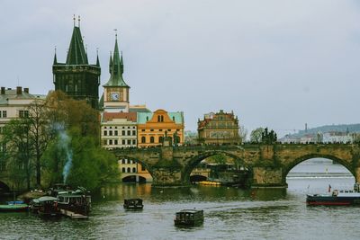 Bridge over river against buildings in city