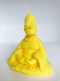 Close-up of yellow statue against white background