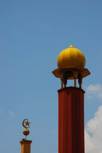 Low angle view of yellow tower against sky