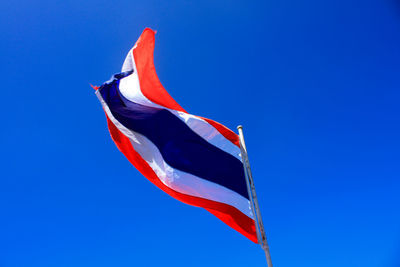 Low angle view of thai flag against clear blue sky