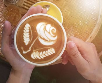 Cropped image of hand holding coffee cup