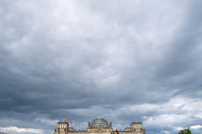 Low angle view of building against cloudy sky