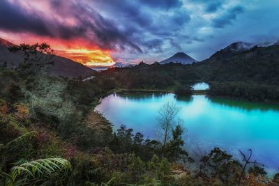 Scenic view of lake by mountains against sky