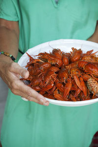 Close-up of woman holding plate full of crayfish, sweden