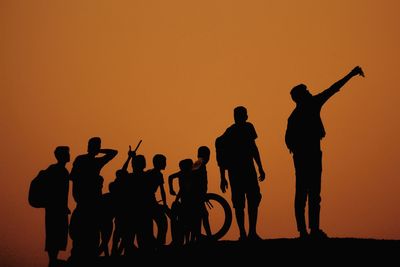 Silhouette people against clear sky during sunset