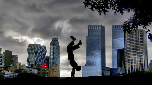 Skyscrapers in city against cloudy sky