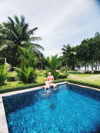 People in swimming pool against sky