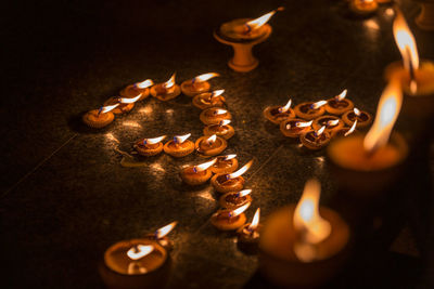 High angle view of lit candles on fire