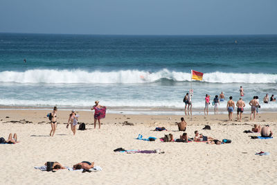 People on beach against clear sky