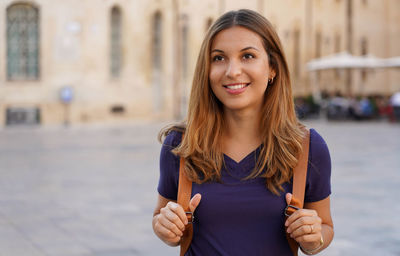 Portrait of smiling young woman standing outdoors