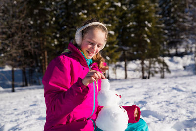 Smiling girl with ice cream in snow