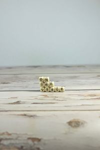 Close-up of text on table by sea against clear sky