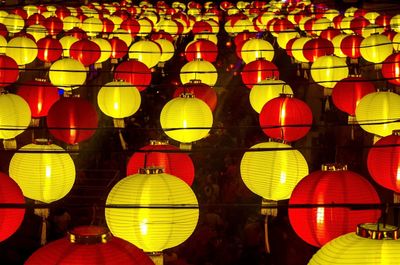 Low angle view of illuminated lanterns hanging at night