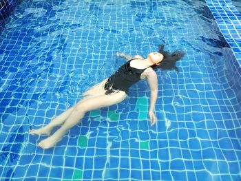 High angle view of young woman swimming in pool