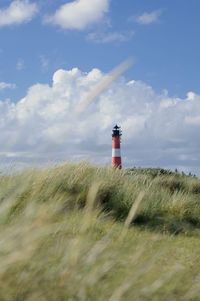 Lighthouse by sea against sky