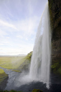 Scenic view of waterfall against sky