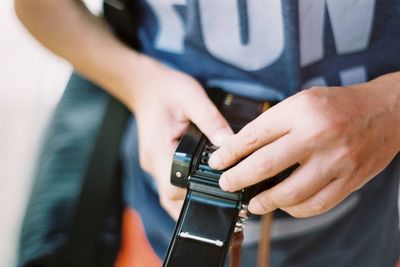 Midsection of man holding camera