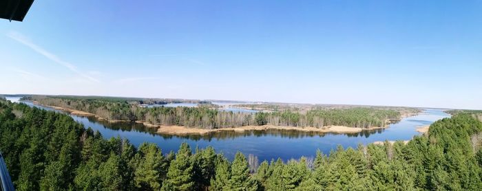 Panoramic view of lake and trees against blue sky