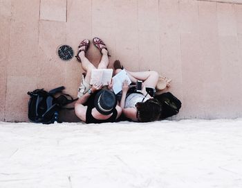 Woman sitting on floor against wall