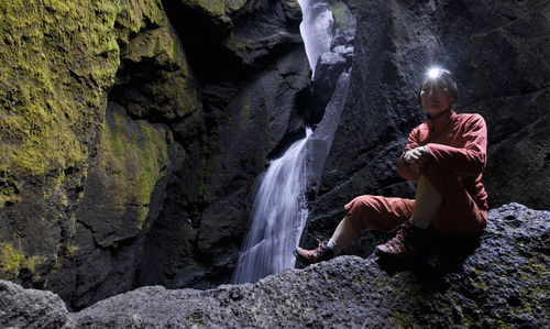 Woman exploring waterfall at the end of a canyon in iceland