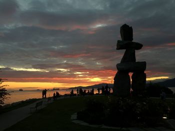 Silhouette cross against sky during sunset