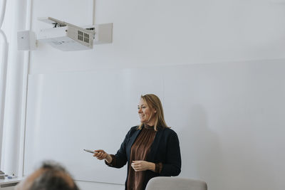 Smiling woman having presentation at meeting