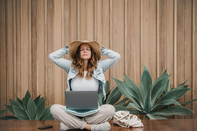 Young woman using laptop while sitting on table