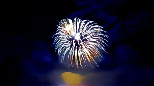 Low angle view of fireworks in sea against sky at night