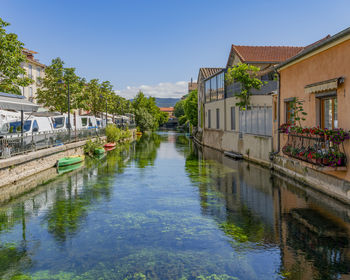 Canal amidst buildings against clear sky