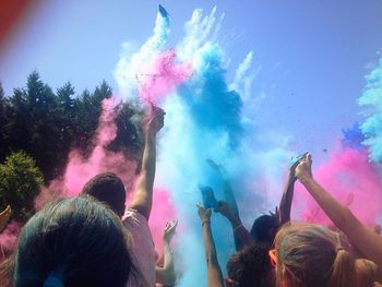 People enjoying holi against sky