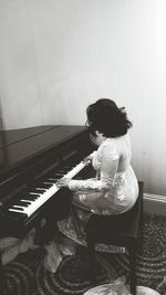 Rear view of a man playing piano