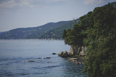 Scenic view of sea and mountains against sky